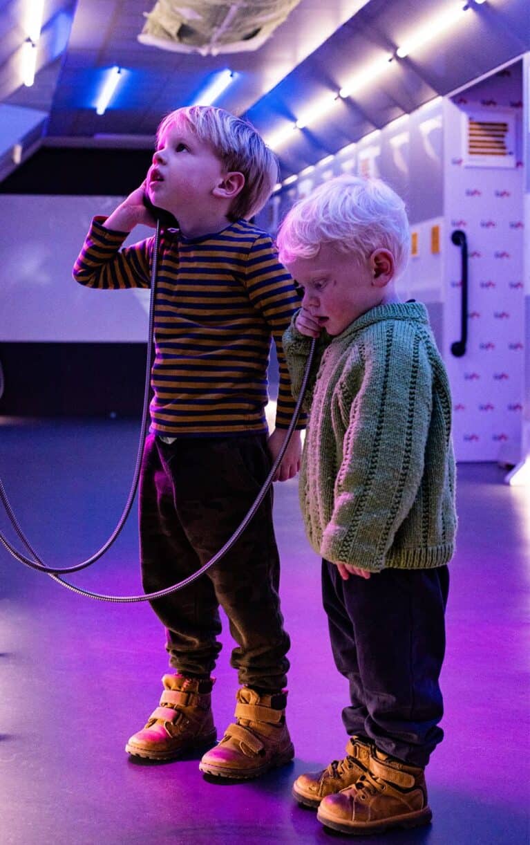 Two young boys listening to an astronaut through headpiece in Life's Space Zone.
