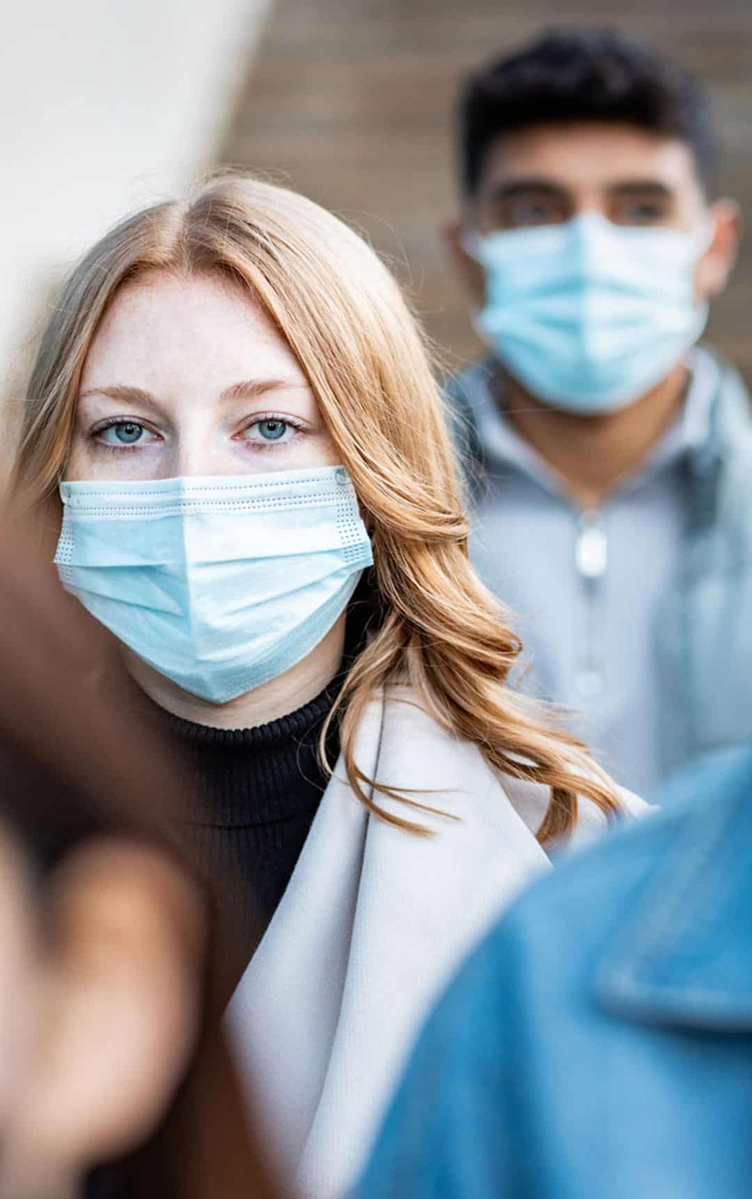 Authentic shot of multiracial people in the city wearing face mask and walking on the pavement commuting to work