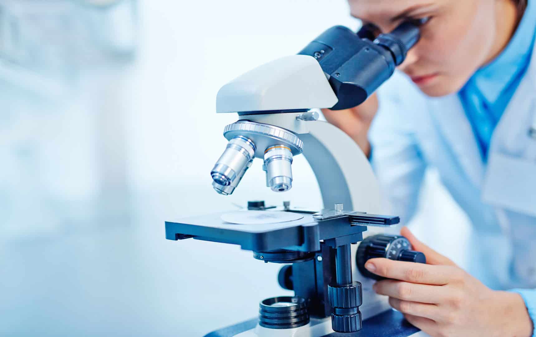Young female chemist studying new substance in lab