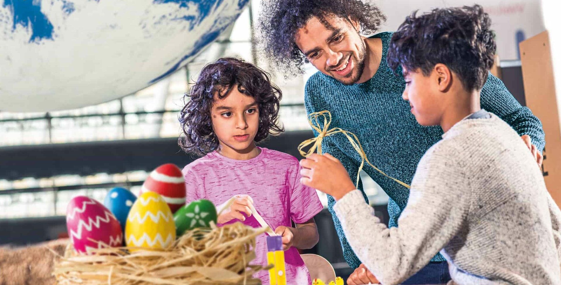 Family Taking Part In Easter Craft Activity In The Making Studios.