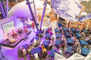 Overhead Shot Of Adults Watching Science Speakeasy Inside The Science Centre.