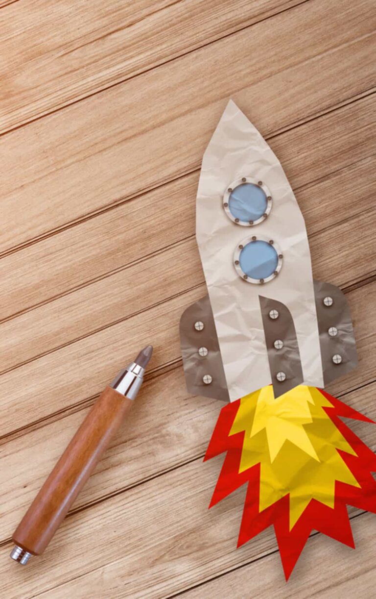 Rocket Paper Cut With Pencil On Wooden Terrace And Hay Texture Background.