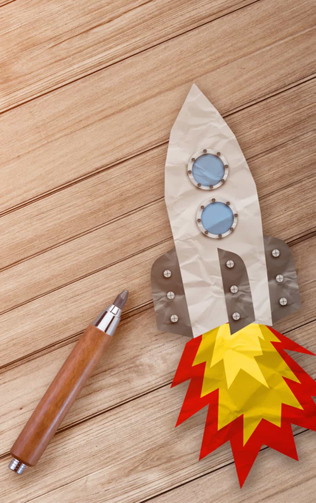 Rocket Paper Cut With Pencil On Wooden Terrace And Hay Texture Background.