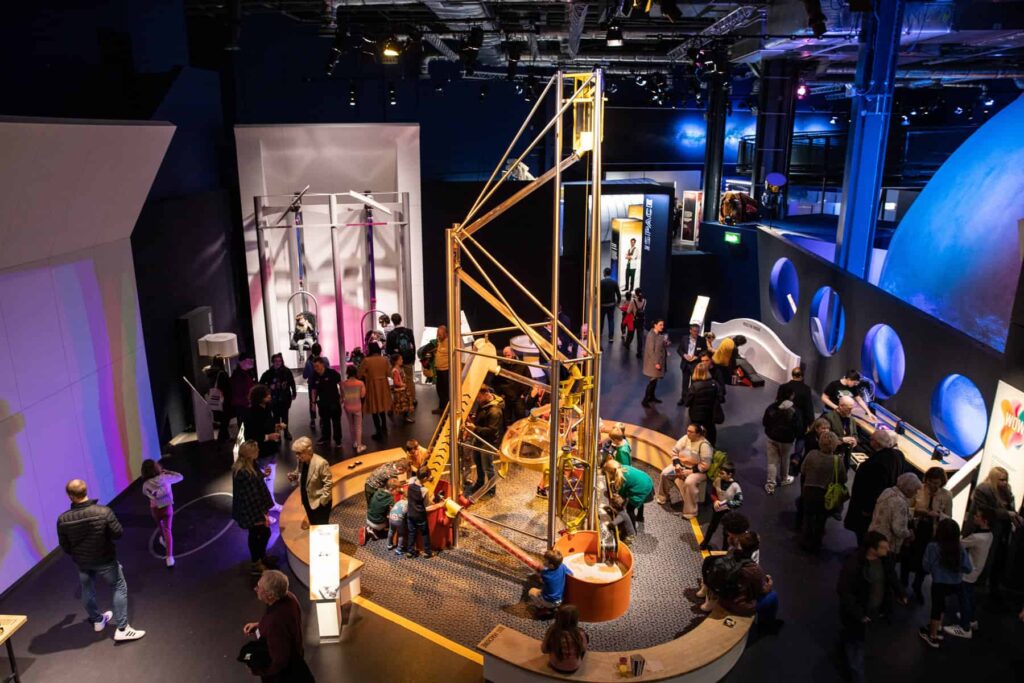 Overhead photo of staff and visitors enjoying Wow Zone exhibits inside the science centre.