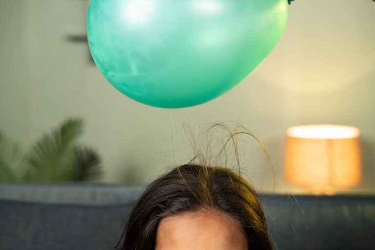Close Up Shot Of Kids Playing By Placing Balloon To Attracting Hair Concept Of Static Cling Home Science Experiment And Learning