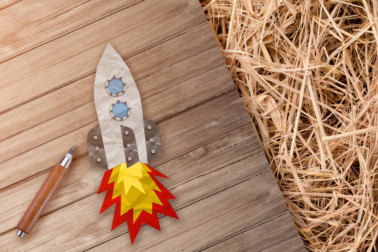 Rocket Paper Cut With Pencil On Wooden Terrace And Hay Texture Background