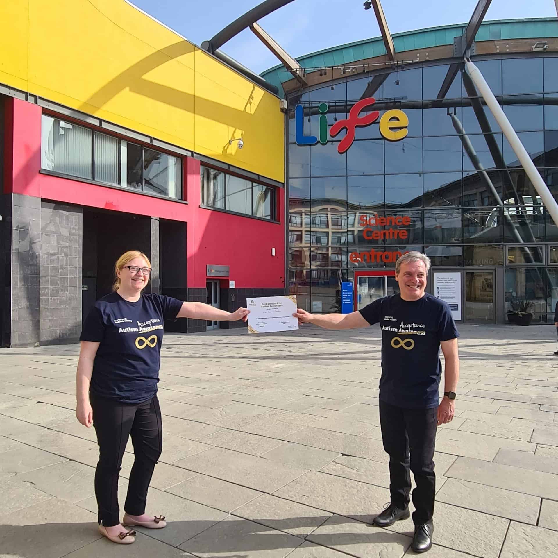 Project leads from North East Autism Society and Life Science Centre standing outside of the centre with Gold Standard Award.