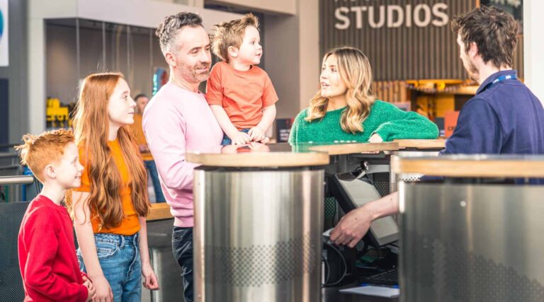 Family of five at reception area purchasing tickets to visit Life Science Centre.