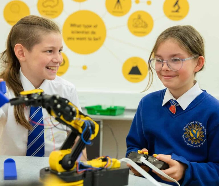 Two children playing with a robot arm.