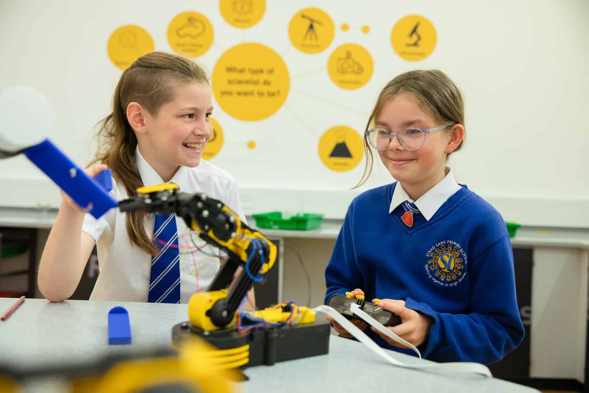 Two children playing with a robot arm.