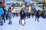 Father and son on Life's outdoor ice rink using penguin skating aid.