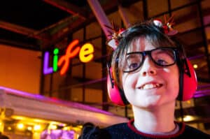 Person wearing ear defenders and reindeer antlers on Newcastle's outdoor ice rink.