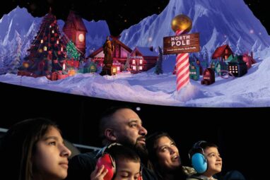 Family in planetarium watching What Santa Sees show and wearing ear defenders.