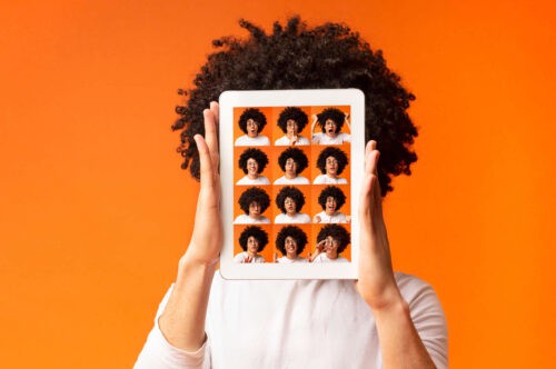 Teenager holding iPad with portraits of 16 emotions being displayed.