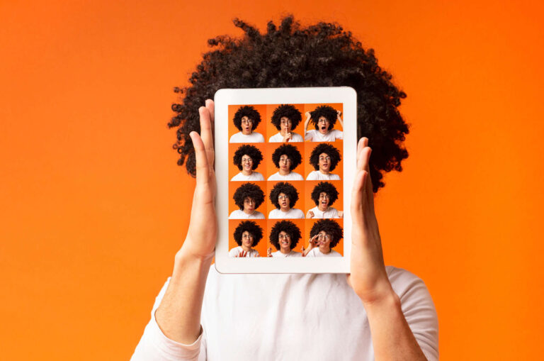 Teenager holding iPad with portraits of 16 emotions being displayed.