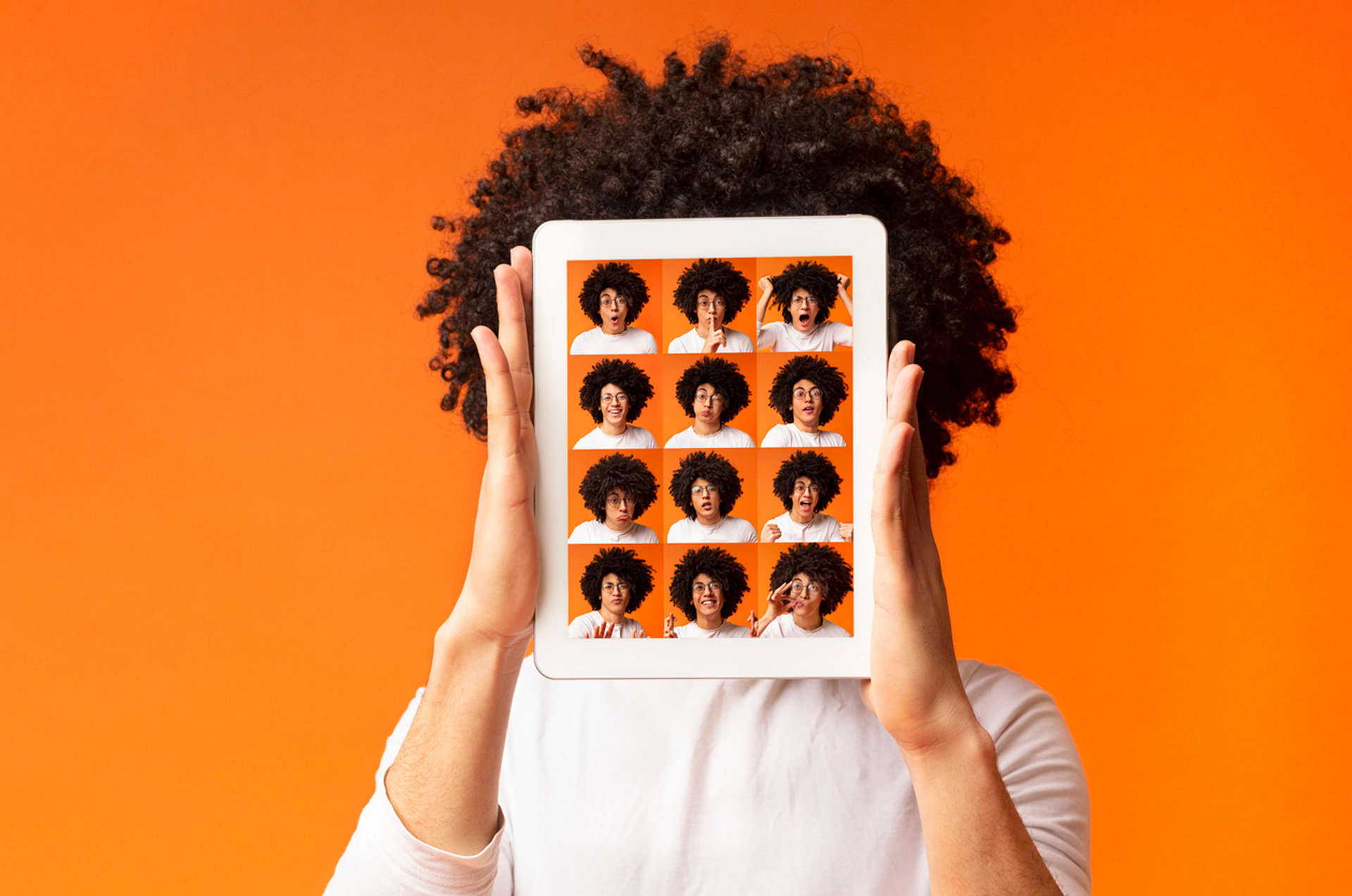 Teenager holding iPad with portraits of 16 emotions being displayed.