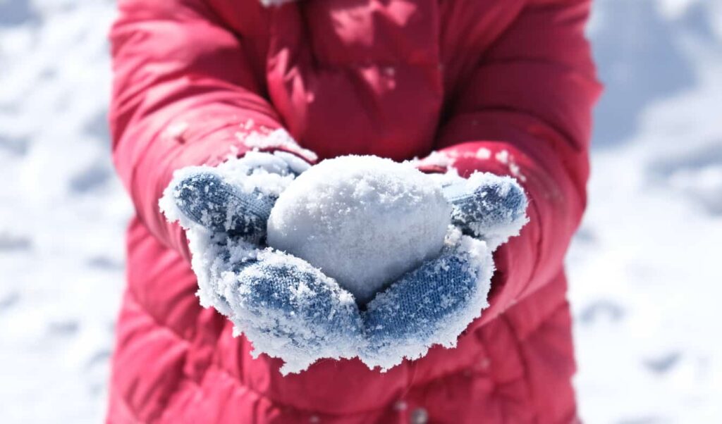 Snowball In Frosty Mittens On The Hands Of A Child.