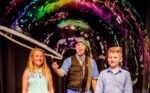 The Highland Joker doing a bubble demonstration with children on stage.