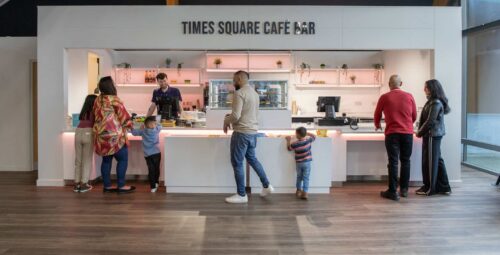 Family ordering food at Times Square Cafe Bar reception in Life Science Centre.
