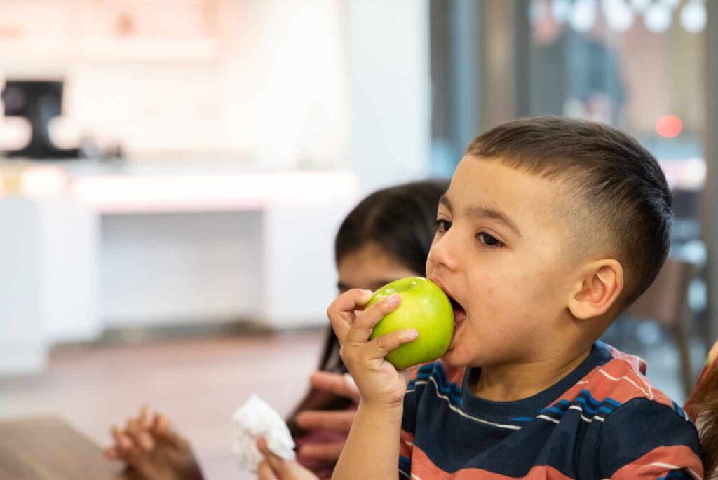 Child eating an apple in Life Science Centre's on-site cafe.