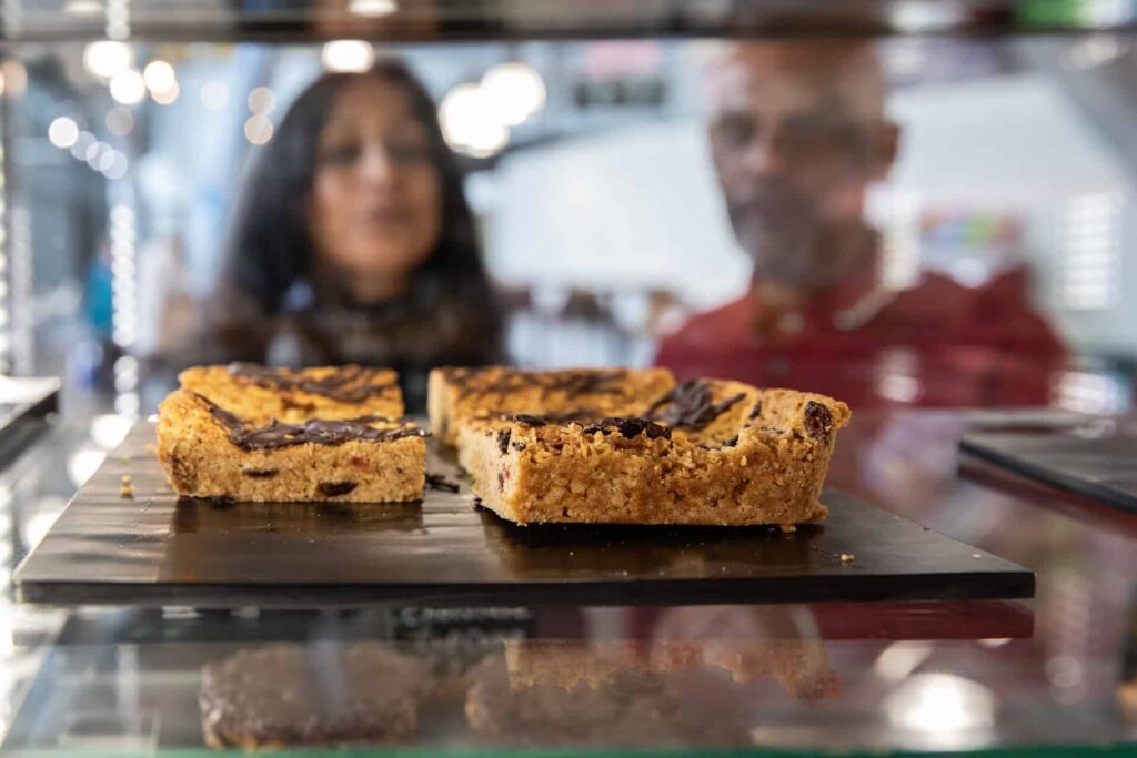 Couple looking through glass at sweet treats in Times Square Cafe.