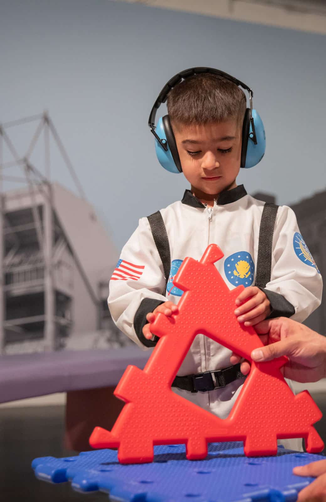 Little boy wearing ear defenders.