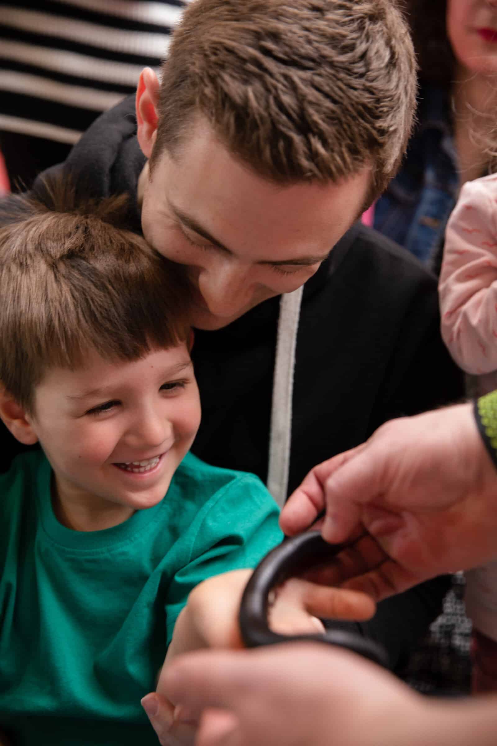 Little boy with father touching a Millipede during May half-term Zoolab show.