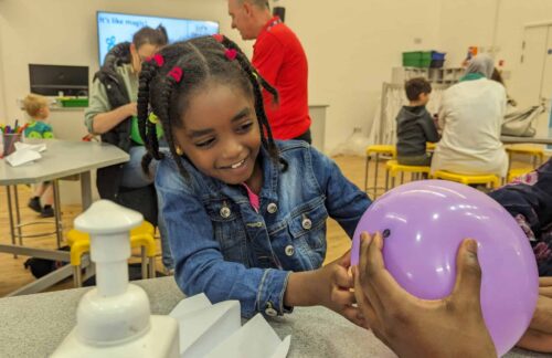 Little girl enjoying balloon activity at Life Science Club.