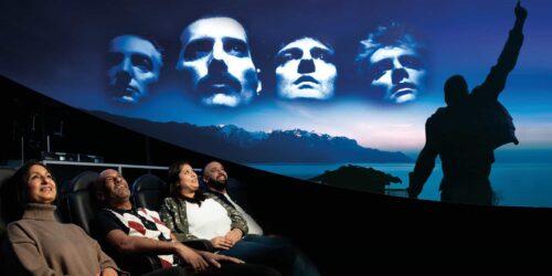 Adults looking up to watch Queen planetarium show at Life Science Centre.