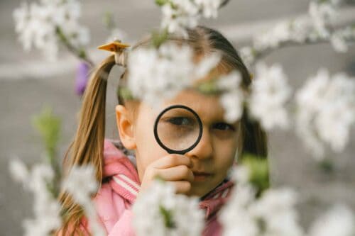 Young child outside exploring nature, participating in Life Science Centre Summer Scavenger Hunt
