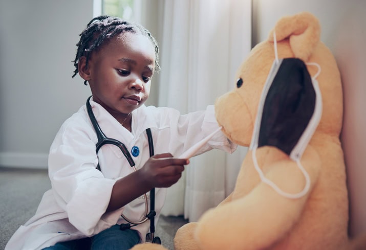 Shot Of A Little Girl Pretending To Be A Doctor While Examining Her Teddybear At Home