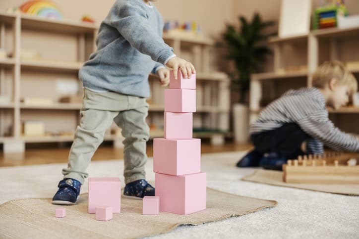 Cropped picture of a little boy making blocks tower at kindergarten.