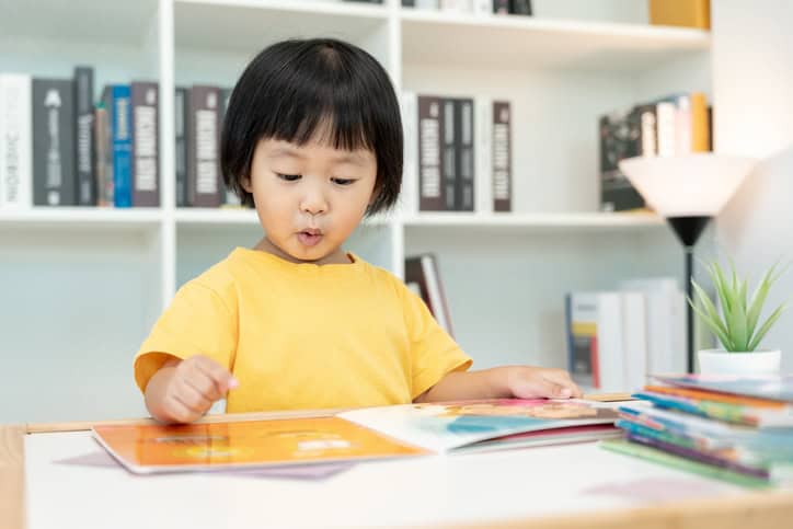 Happy Asian children relax read book at home. daughter and reading a story. learn development, childcare, laughing, education, storytelling, practice, imagine, reduce addiction mobile phone