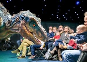 Animated dinosaur meeting visitors during live science show at Life Science Centre.