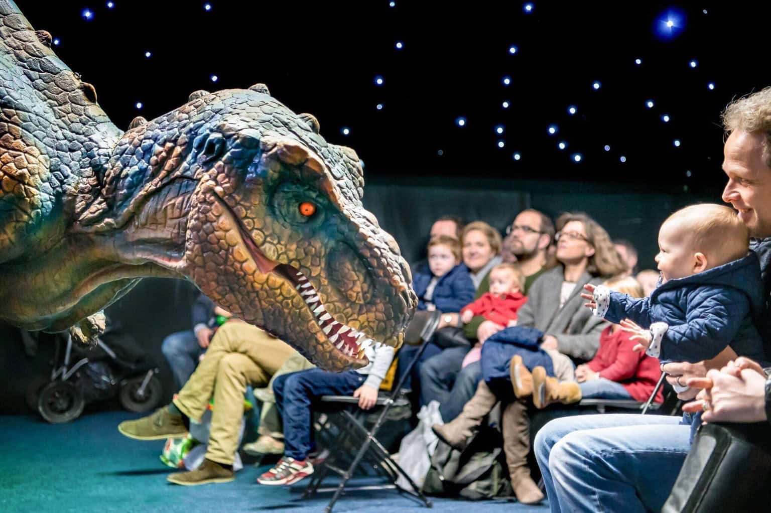 Animated dinosaur meeting visitors during live science show at Life Science Centre.