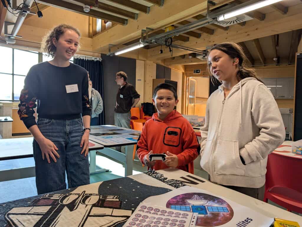 Two children watching demonstration by scientist.