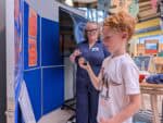Little boy enjoying hands-on activity assisted by scientist.