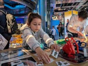 Young girl reaching for something at Spotlight on Space Day in Life Science Centre.