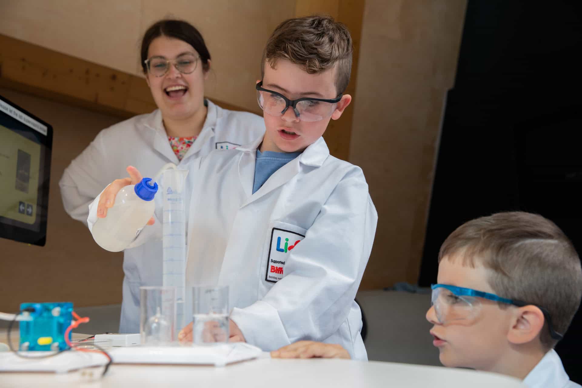 Two boys being assisted by parent with experiment in Newcastle's Life Science Centre.