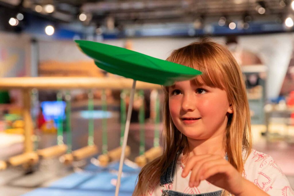 Young girl enjoying plate splitting in Newcastle's Life Science Centre Play Zone.
