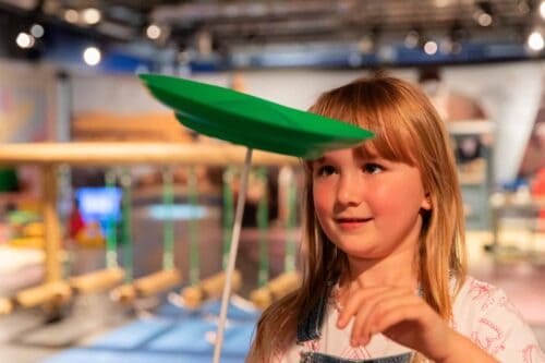 Young girl enjoying plate splitting in Newcastle's Life Science Centre Play Zone.