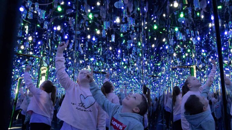 Young children looking up inside Infinity Room of recycled cans - a new exhibit at Life Science Centre in Newcastle.