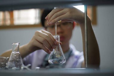 Home educated child doing a titration experience inside science centre.