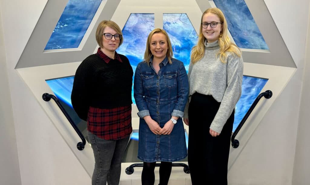 The People Team stood in Life Science Centre's International Space Station mock up window.