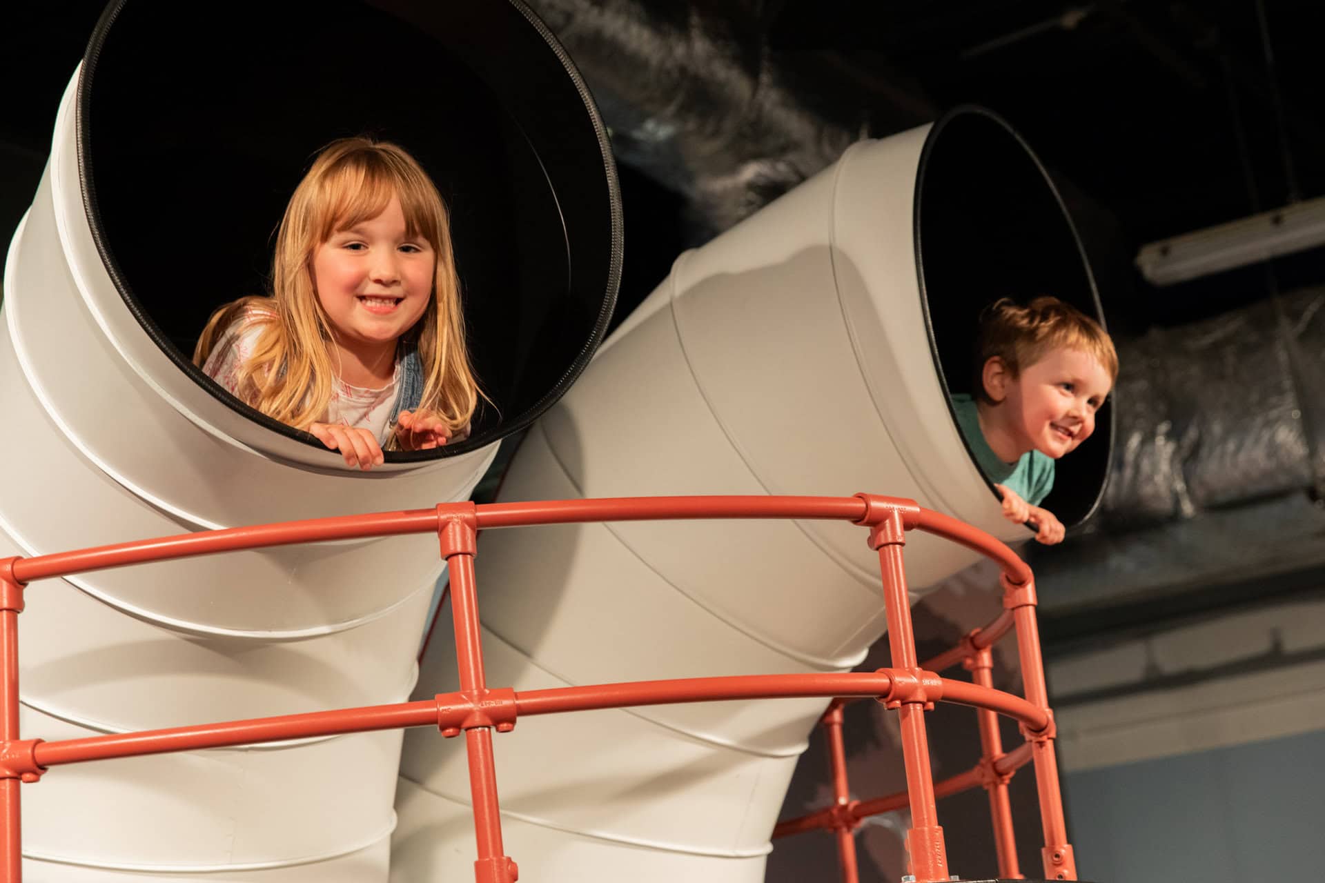 Children leaning out of play boat in Life Science Centre's family friendly area.