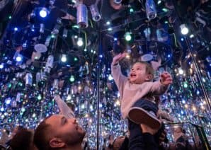 Father holding up child to can in Infinity Room, part of Life Science Centre in Newcastle.