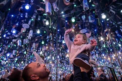 Father holding up child to can in Infinity Room, part of Life Science Centre in Newcastle.
