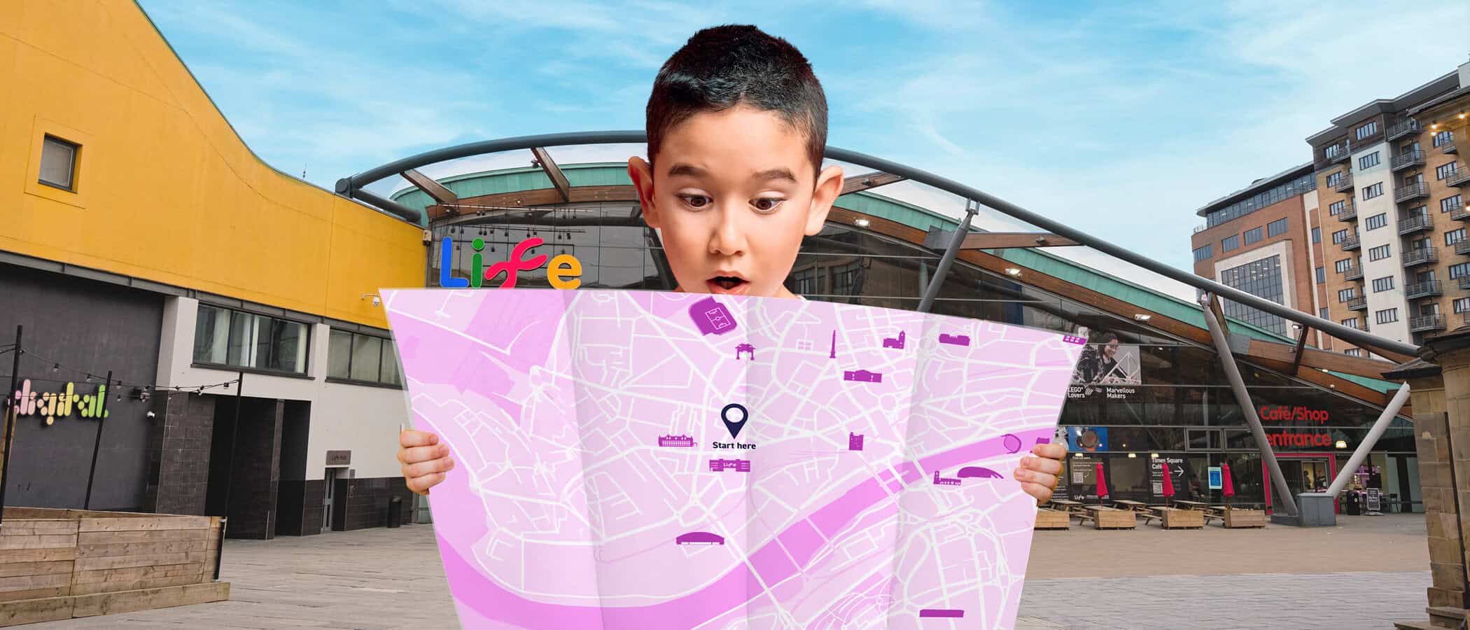 Young boy looking at pink map to find where hidden tickets are
