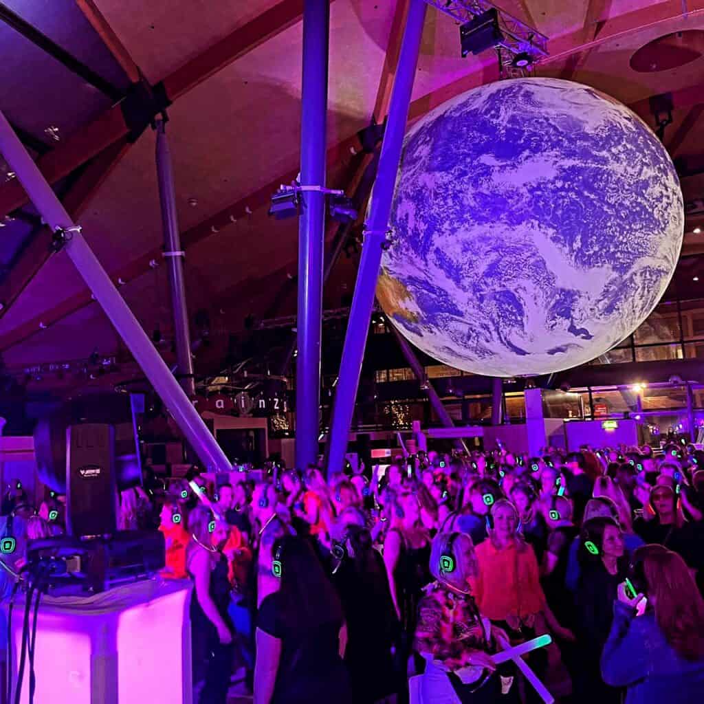 Adults enjoying a silent disco under Gaia inside Newcastle's Life Science Centre.