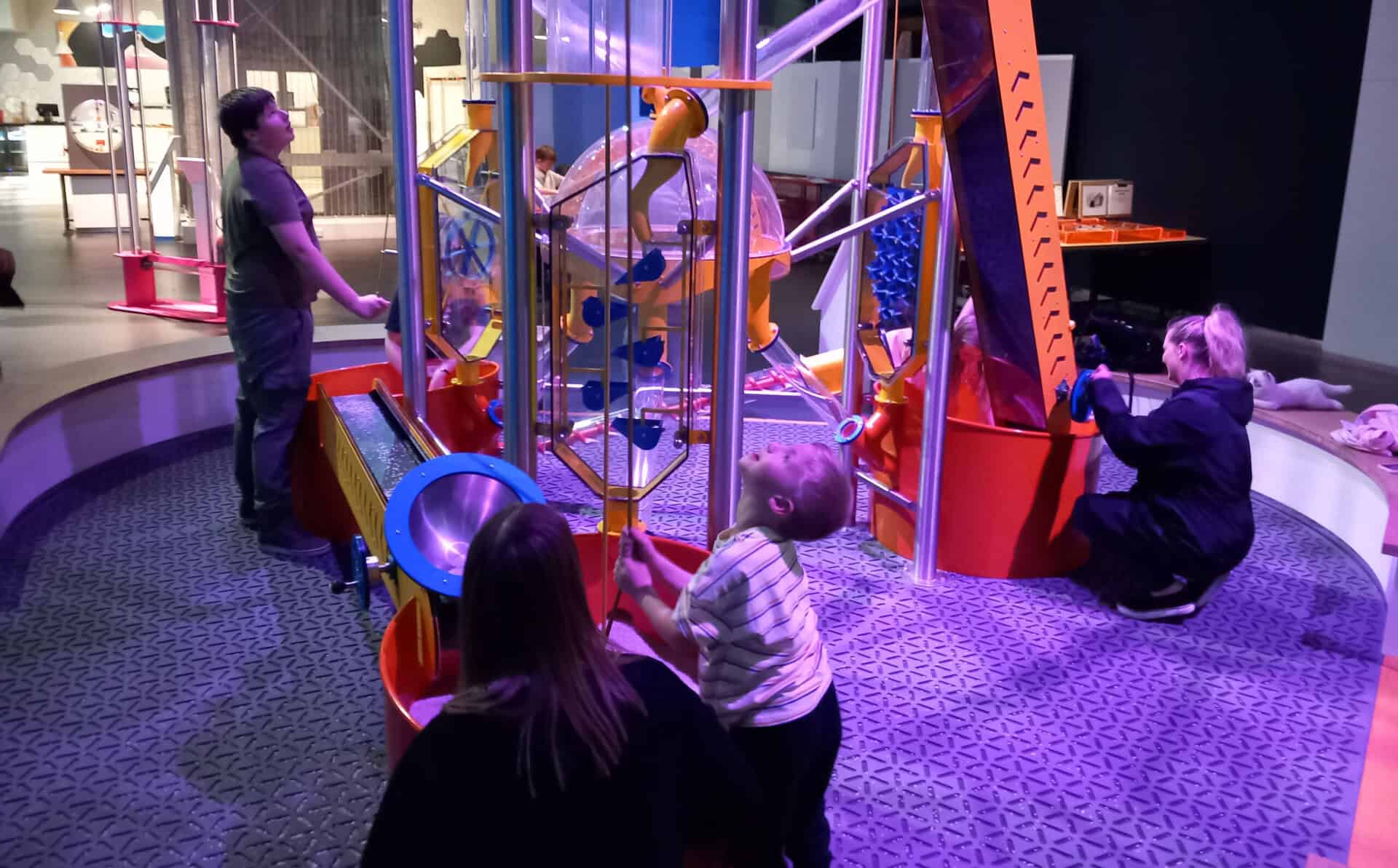 North East Autism Society family gathered around exhibit in Wow Zone.